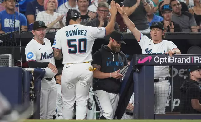 Miami Marlins' Agustín Ramírez (50) is congratulated after scoring on a single hit by Griffin Conine during the fourth inning of a baseball game against the Atlanta Braves, Saturday, Sept. 26, 2026, in Miami. (AP Photo/Lynne Sladky)