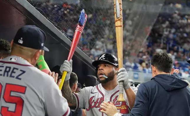 Atlanta Braves' Dominic Smith is congratulated in the dugout after hitting a two run home run during the second inning of a baseball game against the Miami Marlins, Saturday, Sept. 26, 2026, in Miami. (AP Photo/Lynne Sladky)