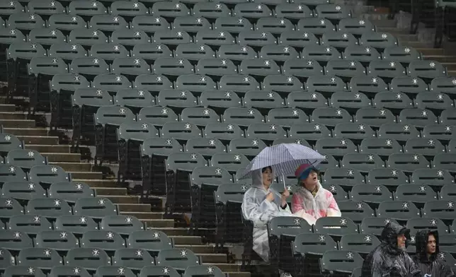 Fans look on during a rain delay before a baseball game between the Chicago White Sox and the Detroit Tigers, Sunday, Sept. 20, 2026, in Chicago. (AP Photo/Paul Beaty)