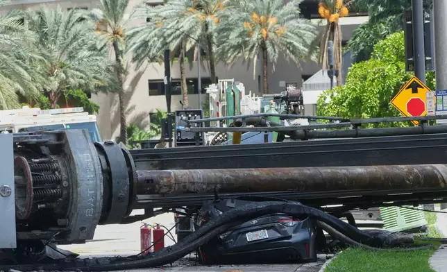 A large construction crane collapsed and crushed a car on Monday, Sept. 14, 2026, in Miami. (AP Photo/Marta Lavandier)