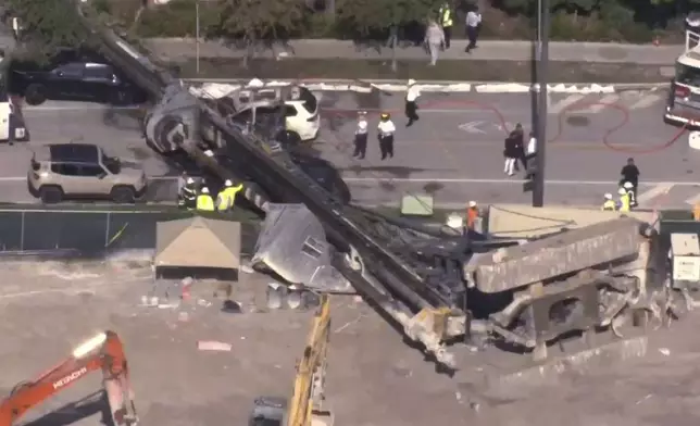 This image taken from a WSVN video shows Miami authorities responding to the scene of a crane that collapsed at a Miami construction site Monday, Sept. 14, 2026. (WSVN via AP)