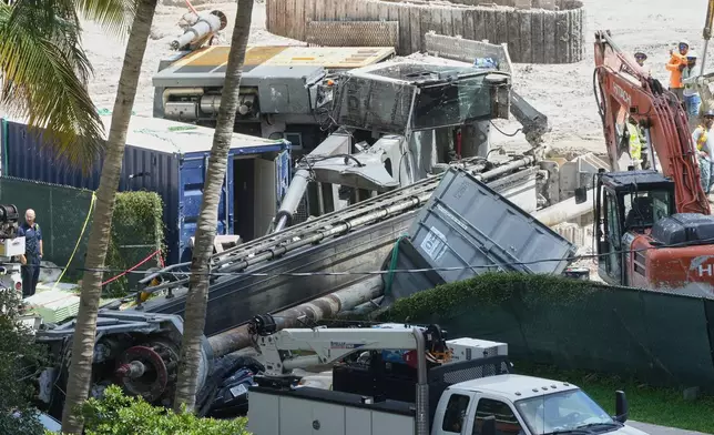 A person stands beside a large construction crane after it collapsed, Monday, Sept. 14, 2026, in Miami. (AP Photo/Marta Lavandier)
