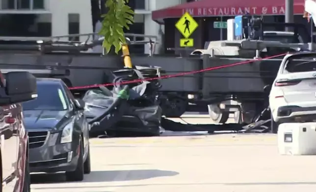 This image taken from a WSVN video shows a crushed vehicle after a crane collapsed at a Miami construction site Monday, Sept. 14, 2026. (WSVN via AP)