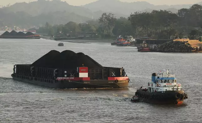 A tug boat pulls a barge loaded with coal on Mahakam River in Samarinda, East Kalimantan, Indonesia, on Aug. 19, 2026. (AP Photo/Ahmad Mulia Panjaitan)