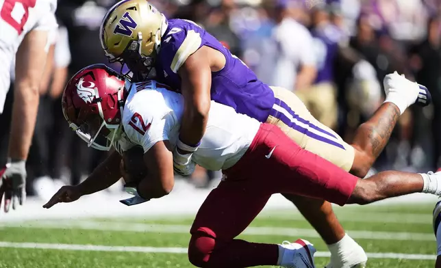 Washington linebacker Xe'ree Alexander tackles Washington State quarterback Caden Pinnick during the first half of an NCAA college football game, Sunday, Sept. 6, 2026, in Seattle. (AP Photo/Lindsey Wasson)