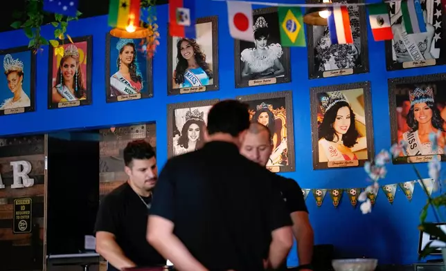 Photos of Venezuelan Miss Universe contestants line a wall at Arempa's restaurant Tuesday, July 14, 2026, in Midvale, Utah. (AP Photo/Gregory Bull)