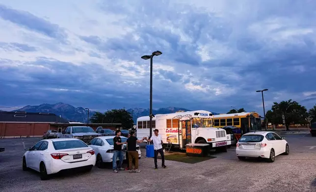 Venezuelan Jadiel Rodriguez greets people in front of his school bus turned store, catering to Venezuelan products Tuesday, July 14, 2026, in Midvale, Utah. (AP Photo/Gregory Bull)