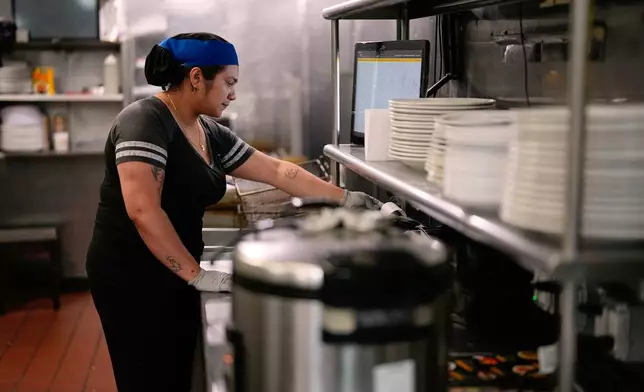 Dayana Ortega works at an Arempa's restaurant Tuesday, July 14, 2026, in Midvale, Utah. (AP Photo/Gregory Bull)