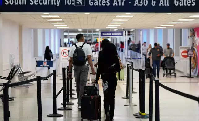 FILE - Travelers walk through TSA security lines at George Bush Intercontinental Airport on March 30, 2026, in Houston. (AP Photo/Ashley Landis, File)
