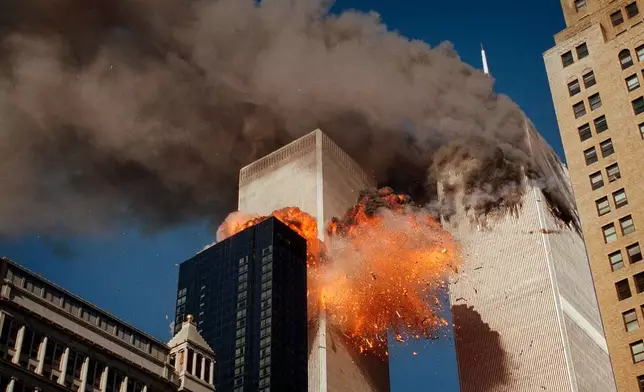 FILE - Smoke billows from one of the towers of the World Trade Center as flames and debris explode from the second tower, Sept. 11, 2001. (AP Photo/Chao Soi Cheong, File)