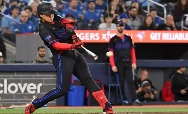 Toronto Blue Jays' Kazuma Okamoto hits an RBI double against the Cincinnati Reds, scoring Alejandro Kirk, during the first inning of a baseball game in Toronto, Friday, Sept. 25, 2026. (Jon Blacker/The Canadian Press via AP)