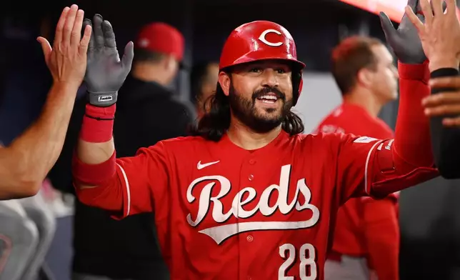 Cincinnati Reds designated hitter Eugenio Suarez (28) celebrates in the dugout after hitting a solo home run against the Toronto Blue Jays during the second inning of a baseball game in Toronto, Friday, Sept. 25, 2026. (Jon Blacker/The Canadian Press via AP)