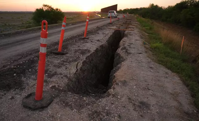 Traffic posts stand around a trench as part of the construction for a new section of border wall at the Santa Ana Wildlife Refuge in Alamo, Texas, as a U.S. Border Patrol vehicle passes through, Tuesday, Aug. 25, 2026. (AP Photo/Eric Gay)