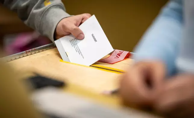 A ballot envelope is placed in a ballot box at a polling station at the City Hall in Malmo, Sweden, Sunday, Sept. 13, 2026. (Johan Nilsson/TT News Agency via AP)