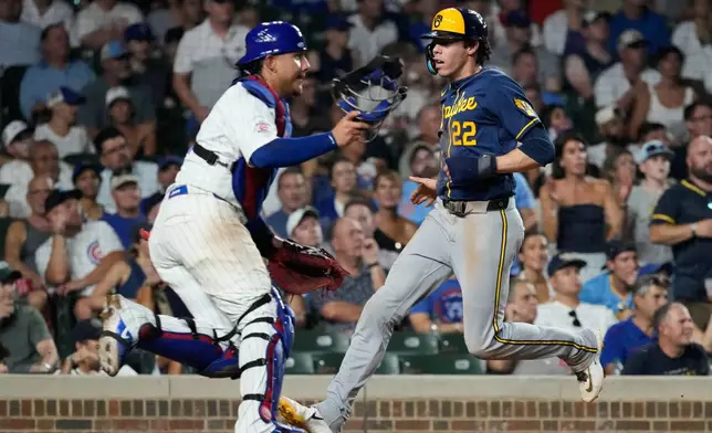 Milwaukee Brewers' Christian Yelich, right, scores on a one-run single by Cooper Pratt as Chicago Cubs catcher Miguel Amaya waits for the ball during the seventh inning of a baseball game in Chicago, Wednesday, Sept. 2, 2026. (AP Photo/Nam Y. Huh)