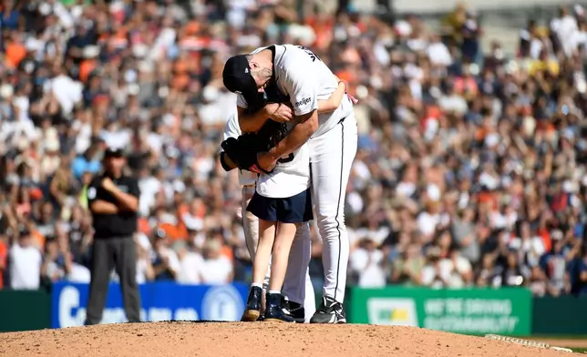 Genevieve Verlander, left, hugs her dad, Detroit Tigers starting pitcher Justin Verlander, during the sixth inning of a baseball game against the Pittsburgh Pirates, Saturday, Sept. 26, 2026, in Detroit. (AP Photo/Jose Juarez)