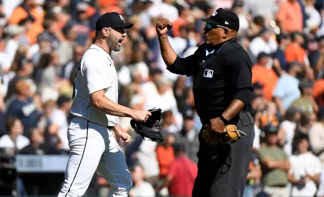Home plate umpire Laz Diaz, right, rules the Pittsburgh Pirates' final out of the fifth inning in a baseball game as Detroit Tigers starting pitcher Justin Verlander reacts d, Saturday, Sept. 26, 2026, in Detroit. (AP Photo/Jose Juarez)
