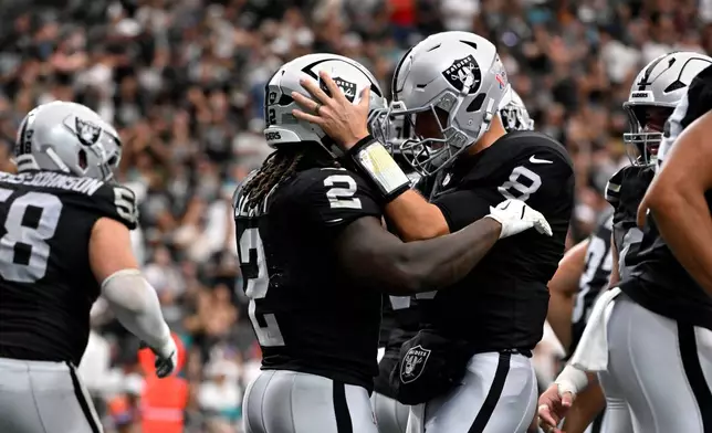Las Vegas Raiders running back Ashton Jeanty (2) celebrates with teammate quarterback Kirk Cousins (8) after catching a touchdown pass during the first half of an NFL football game against the Miami Dolphins, Sunday, Sept. 13, 2026, in Las Vegas. (AP Photo/David Becker)