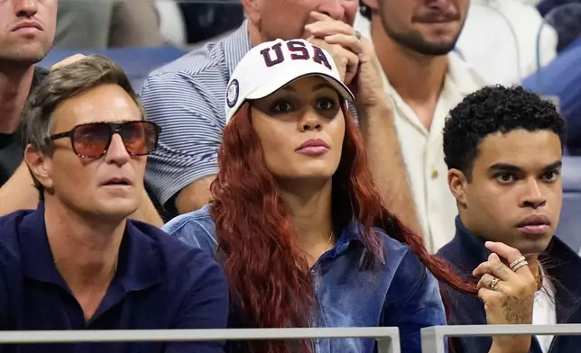 Soccer player Trinity Rodman, center, watches her boyfriend Ben Shelton, of the United States, compete against Frances Tiafoe, of the United States, during the men's singles semifinals of the U.S. Open tennis championships Friday, Sept. 11, 2026, in New York. (AP Photo/Frank Franklin II)
