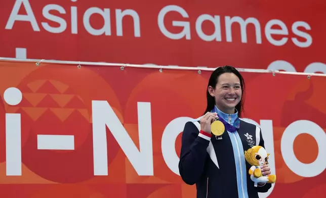 Gold medalist Siobhan Haughey of Hong Kong celebrates on the podium after the women's 200-meter freestyle final in swimming at the Asian Games in Tokyo, Japan, Monday, Sept. 21, 2026. (AP Photo/Hiro Komae)