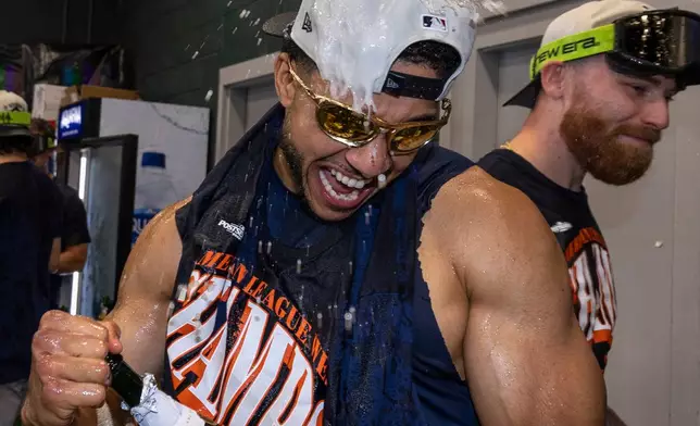 Houston Astros' Jeremy Peña celebrates with teammates after they clinched the AL West division title in a baseball game against the Athletics, Sunday, Sept. 27, 2026, in West Sacramento, Calif. (AP Photo/Sara Nevis)