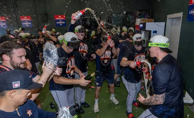Houston Astros celebrate after clinching the AL West division title in a baseball game against the Athletics, Sunday, Sept. 27, 2026, in West Sacramento, Calif. (AP Photo/Sara Nevis)