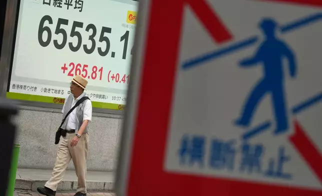 A person walks in front of an electronic stock board showing Japan's Nikkei index at a securities firm Wednesday, Sept. 9, 2026, in Tokyo. (AP Photo/Eugene Hoshiko)