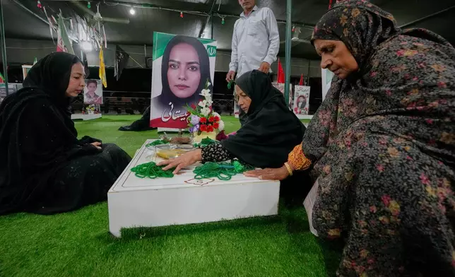 Fatemeh Barani, second from right, mourns at the grave of her daughter, Nasim Neyestani, a second-grade teacher killed in a U.S. airstrike on Shajareh Tayyebeh school on Feb. 28, in a section of a cemetery set aside for those killed at the school in Minab, southern Iran, Monday, Sept. 7, 2026. (AP Photo/Vahid Salemi)