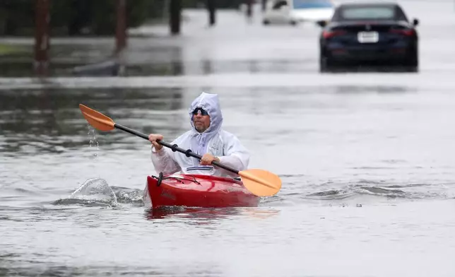 Ted Friedli kayaks his way through a flooded section of Florence Ave. during a nor'easter in Long Branch, N.J., Saturday, Sept. 26, 2026 (AP Photo/Noah K. Murray)