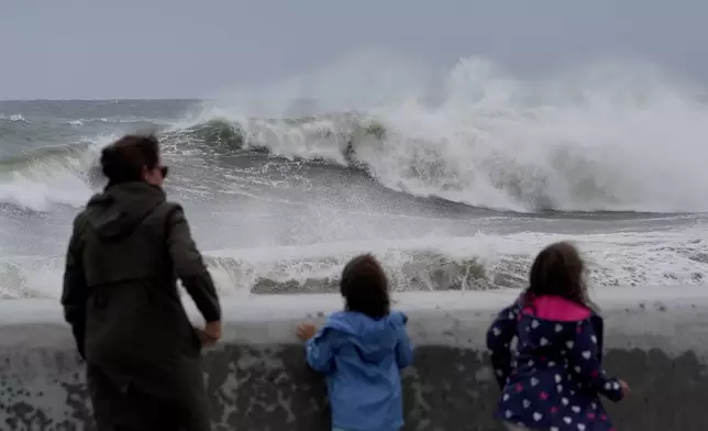 Spectators watch wave break during a nor'easter storm, Saturday, Sept. 26, 2026, in Hampton, N.H. (AP Photo/Robert F. Bukaty)
