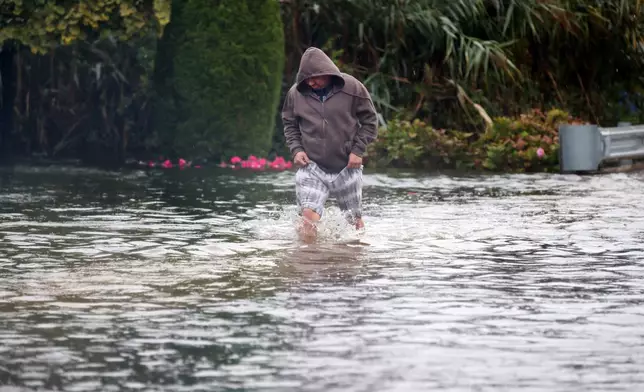 Alberto Montalvo wades through a flooded section of Atlantic Ave. during a nor'easter storm in Long Branch, N.J., Saturday, Sept. 26, 2026. (AP Photo/Noah K. Murray)