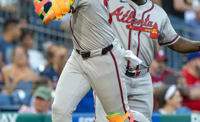 Atlanta Braves' Ronald Acuña Jr., left, celebrates with third base coach Tommy Watkins, right, after hitting a solo home run in the third inning of a baseball game against the Philadelphia Phillies, Saturday, Sept. 5, 2026, in Philadelphia. (AP Photo/Laurence Kesterson)