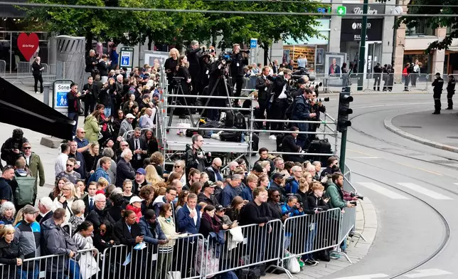 Members of the public wait behind a barrier along the route of the procession for the funeral of Norway's King Harald V near Oslo Cathedral in Oslo, Wednesday, Sept. 9, 2026. (AP Photo/Markus Schreiber)