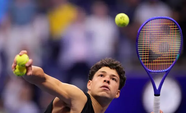 Ben Shelton, of the United States, hits balls to audience after he won his match against Frances Tiafoe, of the United States, during the men's singles semifinals of the U.S. Open tennis championships Friday, Sept. 11, 2026, in New York. (AP Photo/Yuki Iwamura)