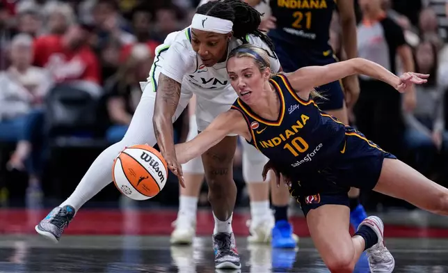 Indiana Fever guard Lexie Hull (10) and Minnesota Lynx forward Liatu King go for a loose ball in the first half of a WNBA basketball game in Indianapolis, Tuesday, Sept. 22, 2026. (AP Photo/Michael Conroy)