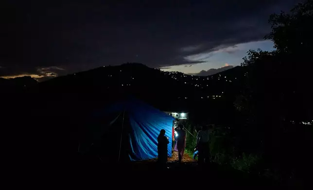 A flood affected woman stands outside temporary shelters for survivors in Nuwakot, Nepal, Tuesday, Sept. 22, 2026. (AP Photo/Niranjan Shrestha)