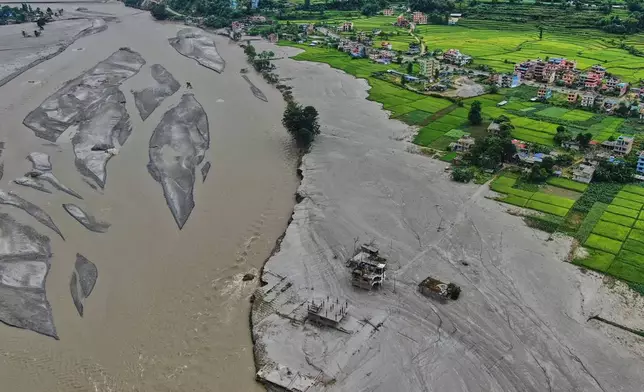 Farmland covered in mud and houses damaged by flash floods are seen along the banks of the Trishuli River in Galchi, in Nepal's Nuwakot district, Wednesday, Sept. 23, 2026. (AP Photo/Niranjan Shrestha)