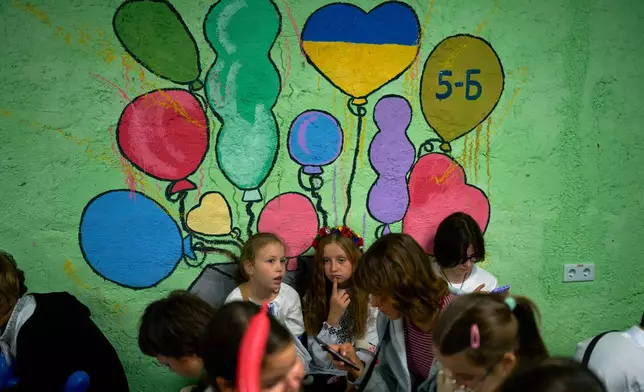 Children sit in an underground shelter during an air raid alarm during the traditional back to school celebrations in Kyiv, Tuesday, Sept. 1, 2026. (AP Photo/Francisco Seco)