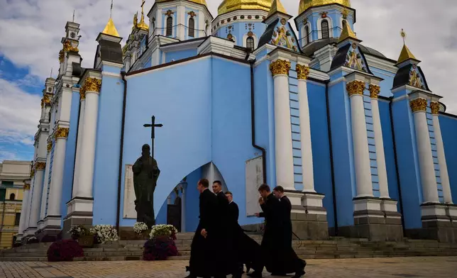 A group of young Christian Orthodox clerics walk next to St. Michael cathedral in downtown Kyiv, Ukraine, Saturday, Sept. 5, 2026. (AP Photo/Francisco Seco)