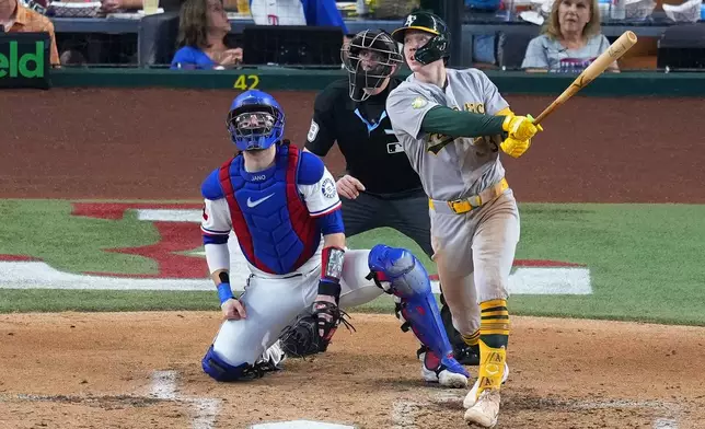 Athletics' Henry Bolte, right, watches his two-run home run as Texas Rangers catcher Danny Jansen, left, and home plate umpire Nic Lentz, center, look on during the fourth inning of a baseball game Wednesday, Sept. 2, 2026, in Arlington, Texas. (AP Photo/Julio Cortez)