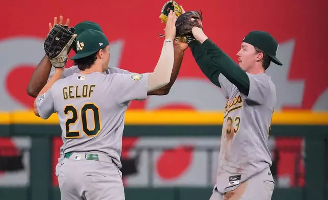 Athletics outfielders Zack Gelof (20), Henry Bolte (33) and Denzel Clarke, back, celebrate their team's victory over the Texas Rangers following a baseball game Wednesday, Sept. 2, 2026, in Arlington, Texas. (AP Photo/Julio Cortez)