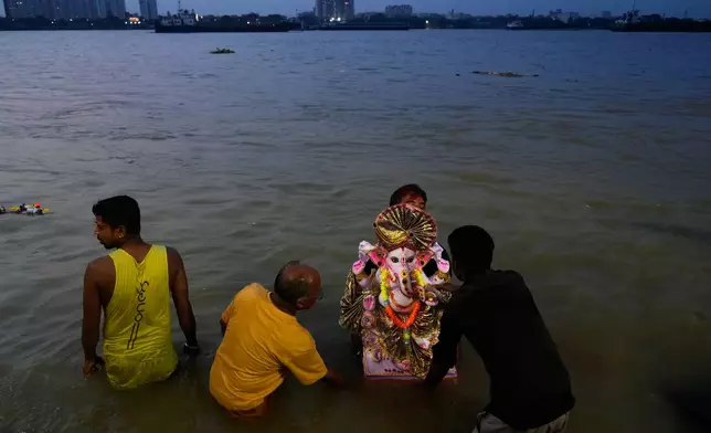 Devotees immerse an idol of elephant-headed Hindu god Ganesha at Hooghly River during Ganesh Chaturthi, in Kolkata, India, Wednesday, Sept. 16, 2026. (AP Photo/Bikas Das)