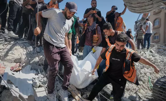 Palestinian civil defense crews carry a body from the rubble of a collapsed building that housed displaced Palestinians and was heavily damaged during the Israel-Hamas war, in Gaza City, Wednesday, Sept. 16, 2026. (AP Photo/Jehad Alshrafi)