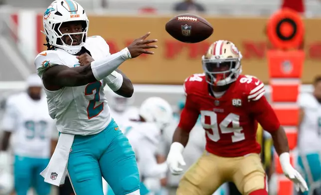 Miami Dolphins quarterback Malik Willis (2) passes next to San Francisco 49ers defensive end Romello Height (94) during the second half of an NFL football game in Santa Clara, Calif., Sunday, Sept. 20, 2026. (AP Photo/Kelley L. Cox)