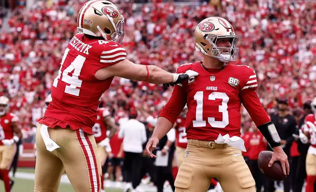 San Francisco 49ers quarterback Brock Purdy (13) is congratulated by fullback Kyle Juszczyk (44) after scoring against the Miami Dolphins during the first half of an NFL football game in Santa Clara, Calif., Sunday, Sept. 20, 2026. (AP Photo/Kelley L. Cox)