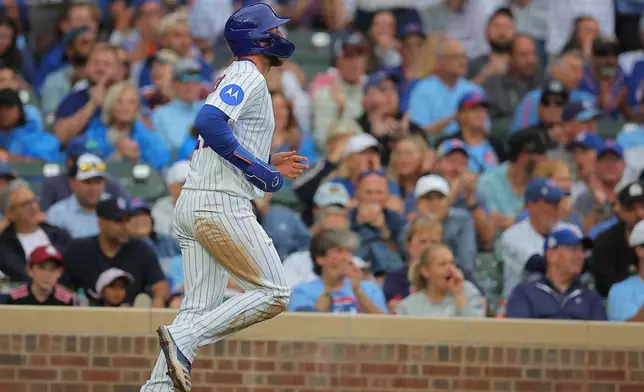 Chicago Cubs' Michael Busch runs to score on a Nico Hoerner groundout to first base during the sixth inning of a baseball game against the Pittsburgh Pirates, Sunday, Sept. 13, 2026, in Chicago. (AP Photo/Melissa Tamez)