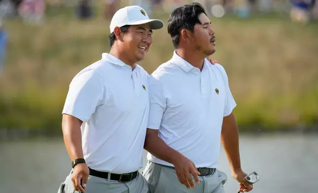 International teams' Tom Kim, of South Korea, laughs after Si Woo Kim, of South Korea, right, missed a putt on the 13th green against the USA team during a Presidents Cup golf tournament third round foursome match at Medinah Country Club, Saturday, Sept. 26, 2026, in Medinah, Ill. (AP Photo/Chris Carlson)