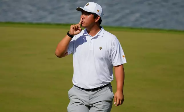 International teams' Tom Kim, of South Korea, reacts after his shot on the 12th green against the USA team during a Presidents Cup golf tournament third round four-ball match at Medinah Country Club, Saturday, Sept. 26, 2026, in Medinah, Ill. (AP Photo/Chris Carlson)