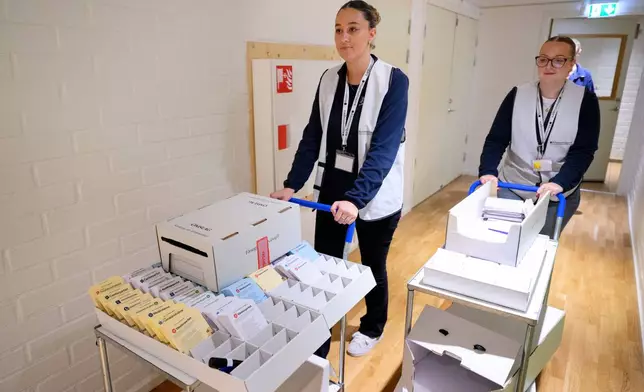 Election workers Felicia Platner and Nora Aissaoui visit the Vardaga Kullabo nursing home with a mobile polling station, in in Huddinge, Sweden, Friday, Sept. 11, 2026. (Jessica Gow/TT via AP)