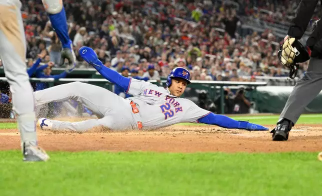 New York Mets' Juan Soto slides home to score on a sacrifice fly hit by Mark Vientos during the third inning of a baseball game against the Washington Nationals, Friday, Sept. 25, 2026, in Washington. (AP Photo/Nick Wass)